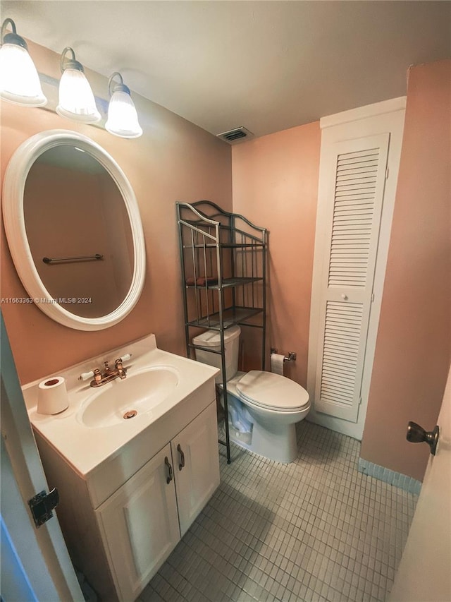 bathroom with tile patterned flooring, vanity, and toilet