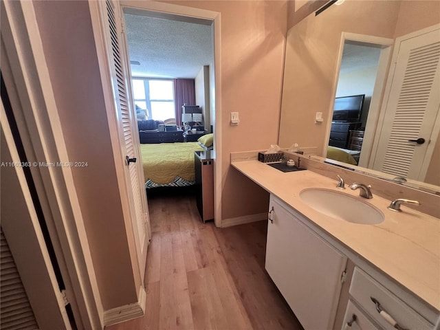 bathroom with vanity, wood-type flooring, and a textured ceiling