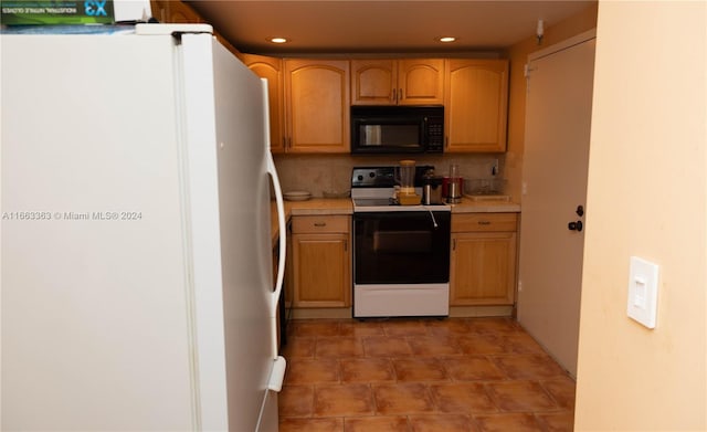 kitchen with tasteful backsplash, tile patterned floors, and white appliances