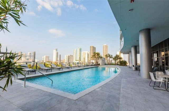 community pool featuring a view of city and a patio