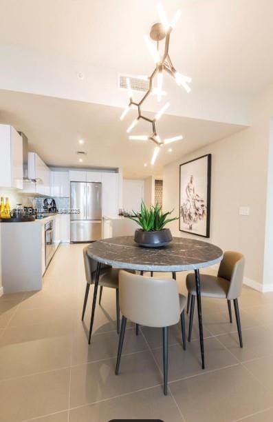 dining area featuring light tile patterned floors, baseboards, and visible vents