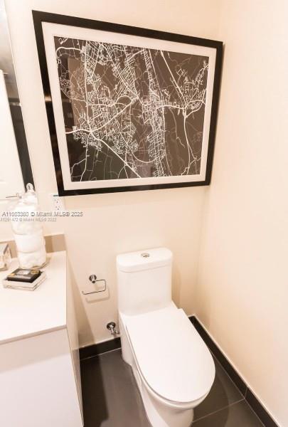 bathroom with toilet, baseboards, and vanity