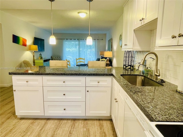 kitchen featuring white cabinets, kitchen peninsula, hanging light fixtures, and sink