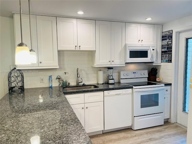 kitchen featuring white cabinets, sink, white appliances, and hanging light fixtures