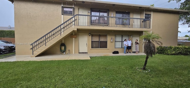 rear view of property with a lawn and a patio area