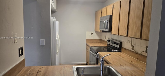 kitchen featuring tasteful backsplash, sink, and appliances with stainless steel finishes