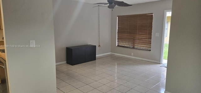 tiled spare room featuring ceiling fan