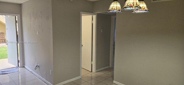 hallway featuring light tile patterned floors and an inviting chandelier