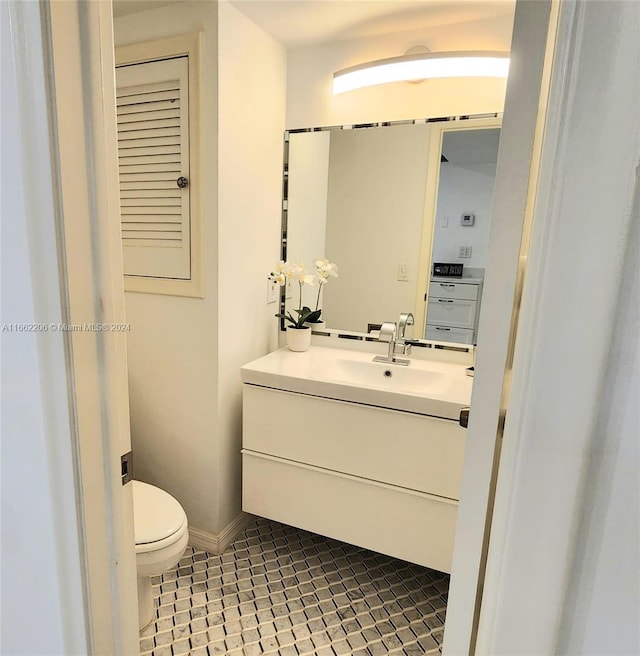 bathroom featuring tile patterned flooring, vanity, and toilet