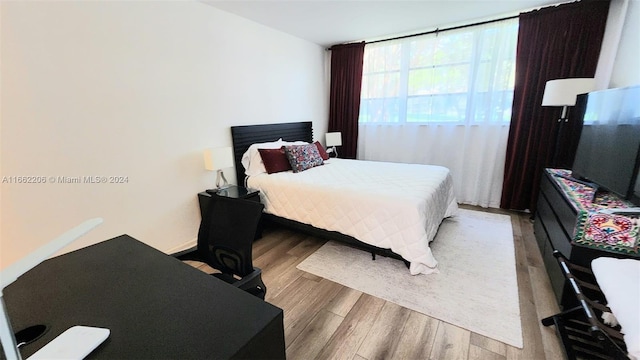 bedroom featuring light hardwood / wood-style flooring and a wall of windows