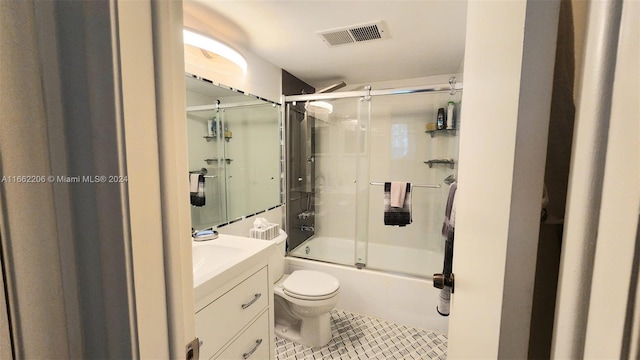 full bathroom featuring combined bath / shower with glass door, tile patterned floors, vanity, and toilet