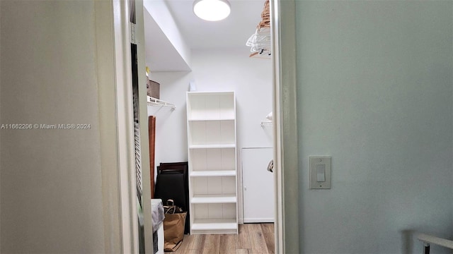 walk in closet with light hardwood / wood-style floors