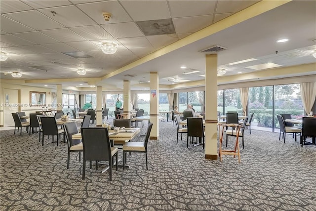 carpeted dining room with a drop ceiling and plenty of natural light