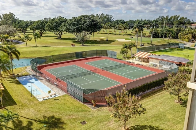 view of tennis court with a lawn and basketball hoop