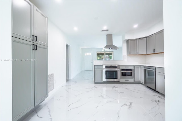 kitchen with gray cabinetry, stainless steel appliances, and extractor fan