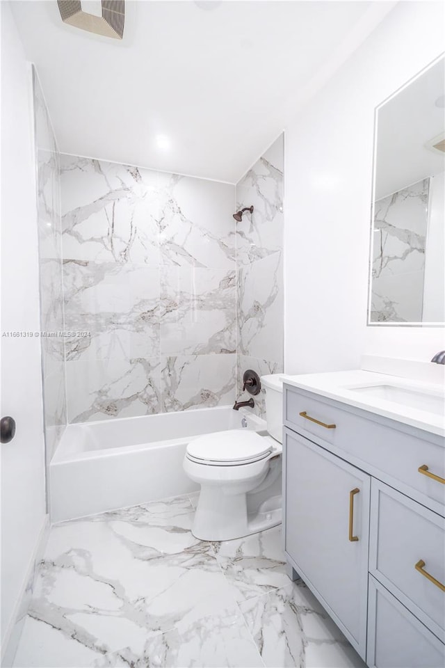 full bathroom featuring vanity, tiled shower / bath combo, and toilet