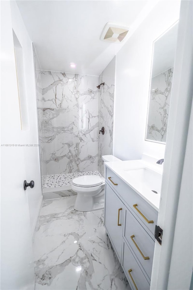 full bath with marble finish floor, toilet, vanity, and a marble finish shower