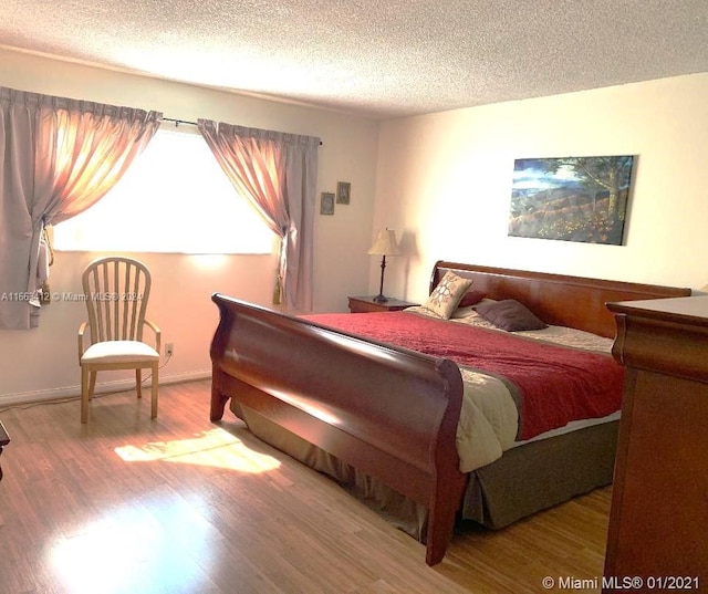 bedroom featuring hardwood / wood-style floors and a textured ceiling