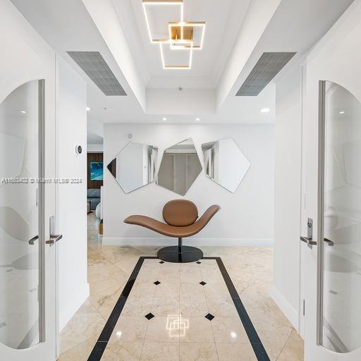 hallway featuring a raised ceiling and french doors