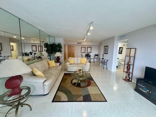 tiled living room featuring rail lighting