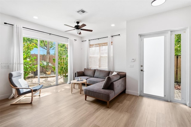 living room with ceiling fan and light hardwood / wood-style flooring