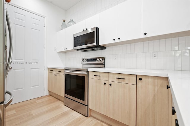 kitchen with light brown cabinets, white cabinetry, stainless steel appliances, light wood-type flooring, and decorative backsplash