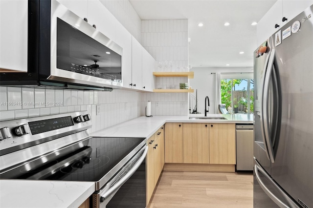 kitchen with light stone counters, ceiling fan, sink, appliances with stainless steel finishes, and light brown cabinetry