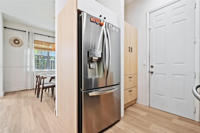 kitchen with light hardwood / wood-style flooring, stainless steel fridge with ice dispenser, and white cabinetry