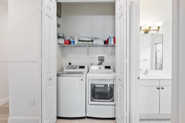 laundry area with washing machine and clothes dryer, light tile patterned floors, and sink