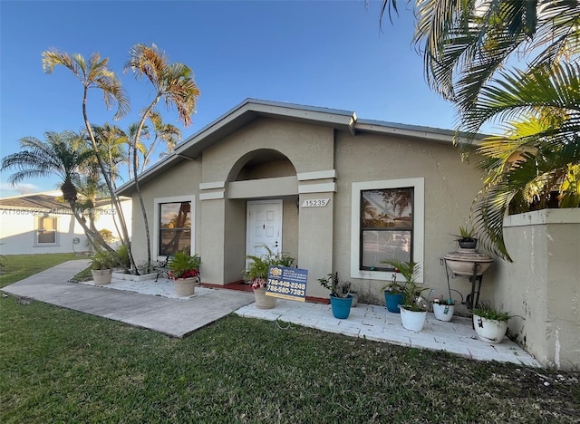 15235 SW 64th Ter Unit 9-35, Miami, FL 33193 - view of exterior entry with stucco siding and a lawn