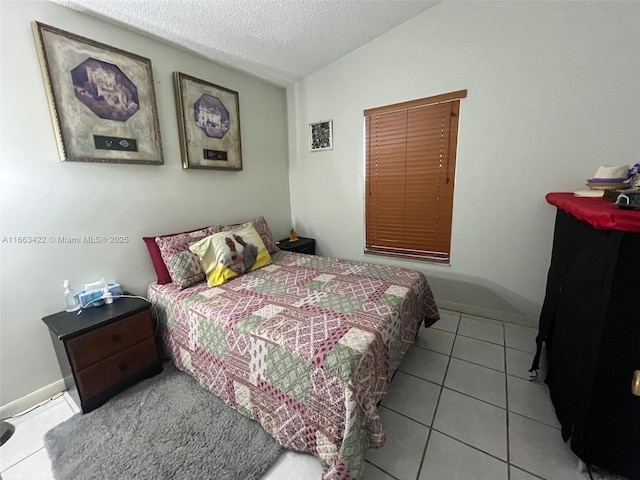 tiled bedroom featuring baseboards, lofted ceiling, and a textured ceiling