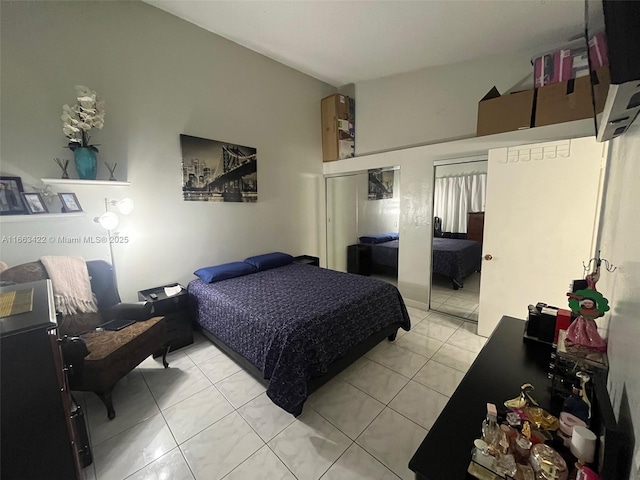 bedroom with light tile patterned flooring and multiple closets