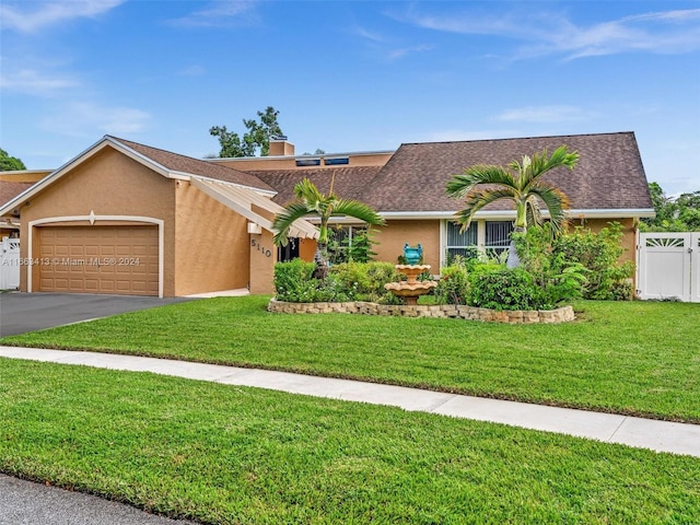 ranch-style house featuring a front yard and a garage