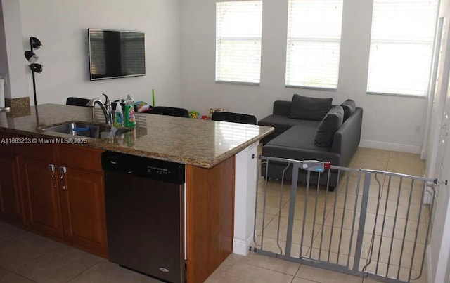 kitchen with light stone countertops, light tile patterned flooring, sink, and dishwashing machine