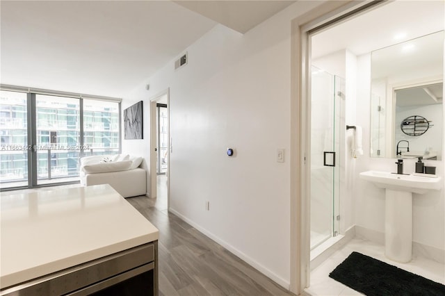 bathroom with hardwood / wood-style floors, an enclosed shower, and beverage cooler