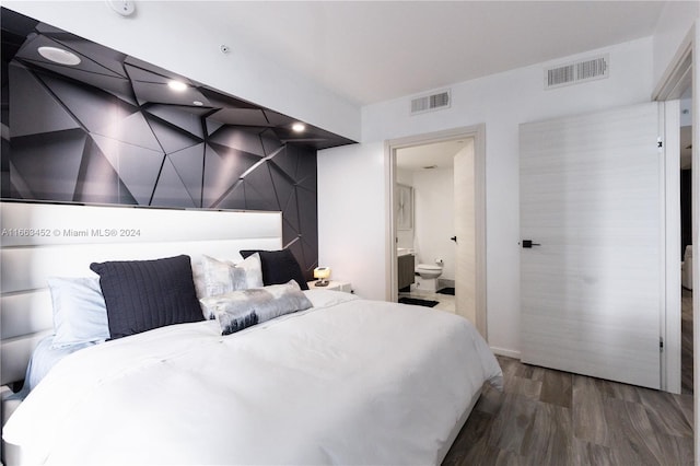 bedroom with dark hardwood / wood-style floors and ensuite bath