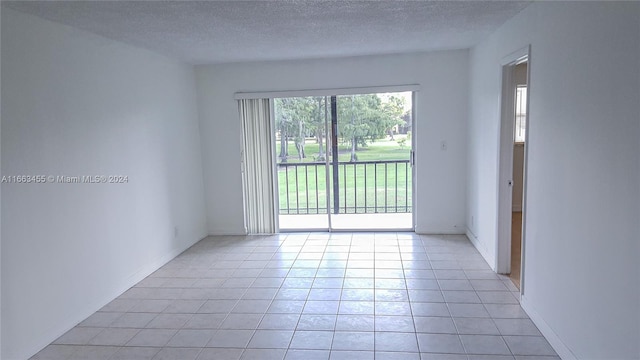 unfurnished room with a textured ceiling and light tile patterned floors