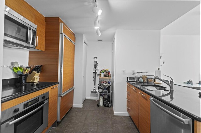 kitchen featuring tile patterned flooring, sink, kitchen peninsula, appliances with stainless steel finishes, and a kitchen breakfast bar