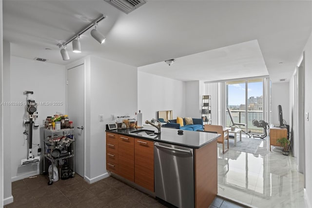 kitchen featuring dark countertops, visible vents, stainless steel dishwasher, brown cabinetry, and a sink