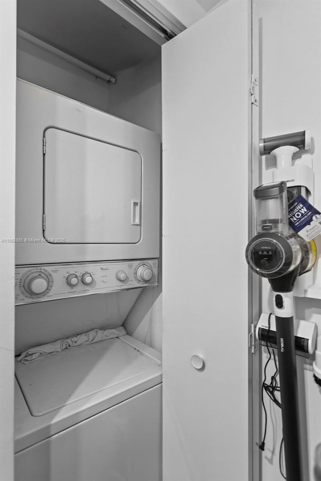 clothes washing area featuring laundry area and stacked washing maching and dryer