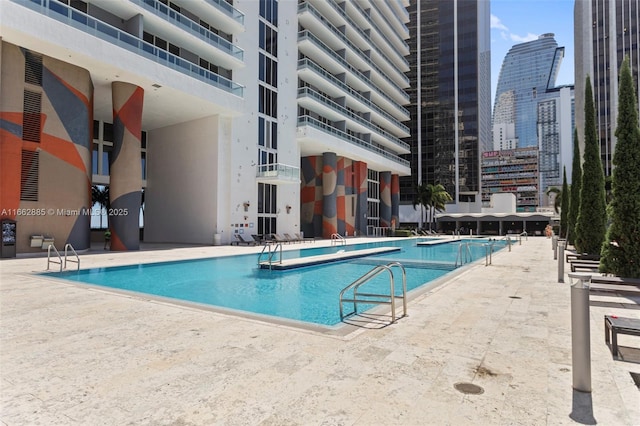 pool featuring a view of city and a patio area