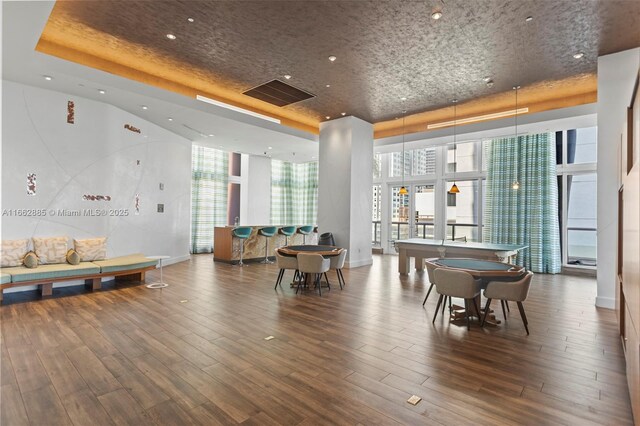 living room with a high ceiling, expansive windows, and light wood-type flooring