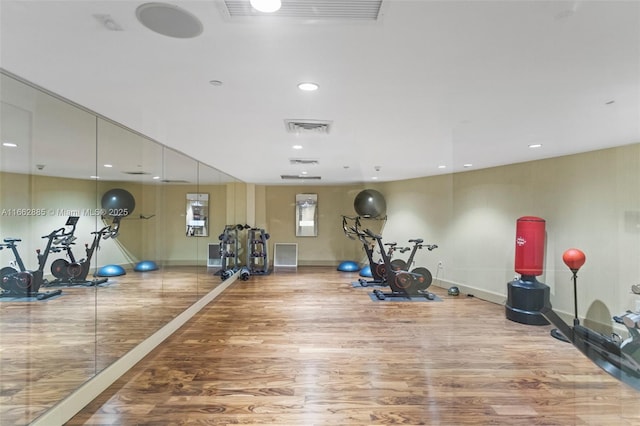 workout area featuring recessed lighting, visible vents, baseboards, and wood finished floors