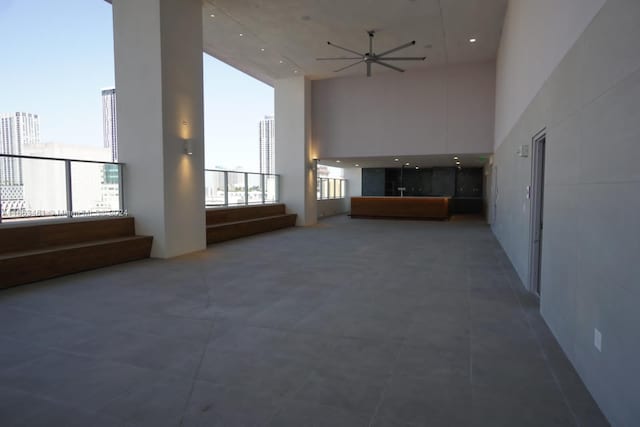 unfurnished living room featuring tile patterned flooring and a towering ceiling