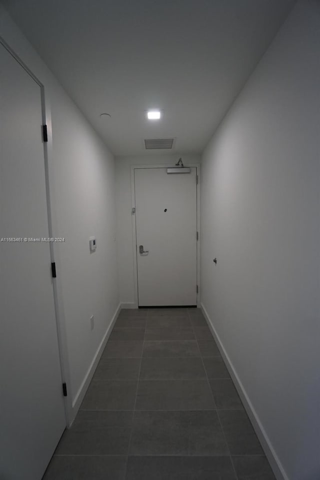 hall featuring dark tile patterned floors