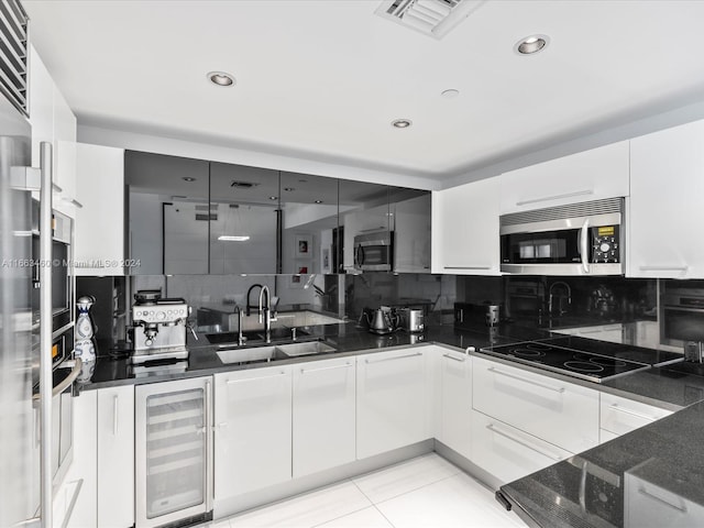 kitchen featuring backsplash, sink, wine cooler, and white cabinets