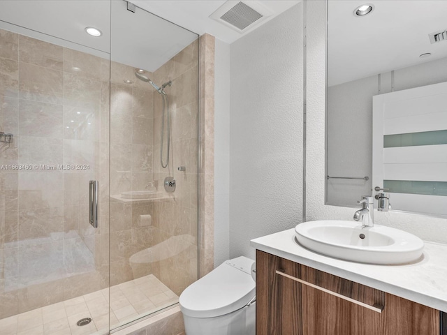 bathroom with vanity, a shower with shower door, and toilet