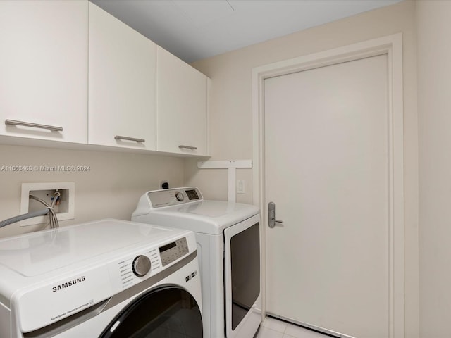 laundry area with cabinets, washing machine and clothes dryer, and light tile patterned floors