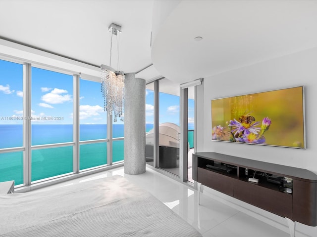 tiled living room with an inviting chandelier, a wall of windows, and a water view