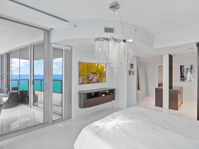 bedroom with a water view, a chandelier, light tile patterned floors, and access to exterior